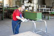 © mdworschak - Blue collar industrial worker polishing a piece of metal in a manufacturing facility