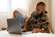 © Eloisa Ramos/Stocksy - Modern man using his laptop at home