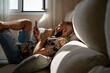 © Eloisa Ramos/Stocksy - Modern man using his phone lying on the sofa