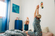 © Olga Moreira/Stocksy - Mother and son stratching in bed in the morning