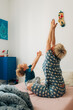 © Olga Moreira/Stocksy - Mother and son stratching in bed in the morning