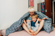 © Olga Moreira/Stocksy - Mom and her 5 years old son playing in bed