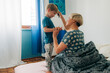 © Olga Moreira/Stocksy - Mother brushing her son while sitting in bed