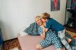 © Olga Moreira/Stocksy - Mother and 5 years old son having fun in bed in the morning
