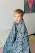 © Olga Moreira/Stocksy - Boy wrapped in blanket