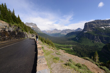 Man enjoy the view of the scenery from the side of the Going to the Sun Road in Glacier National Park in Montana