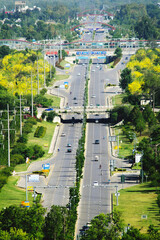 Wall Mural - Vertical shot of cars and bikes passing on a two-way road with a bridge