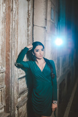 Poster - Young female from Bosnia and Herzegovina in a green elegant dress leaning on the old wall