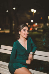 Canvas Print - Vertical shot of a young elegant female in a green dress posing outdoors