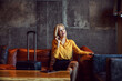 © Dusan Petkovic - An elegant, stylish, happy businesswoman sits in the lobby of the hotel and makes a phone call. There is a laptop and a phone on the table and luggage nearby her. She is on a business trip