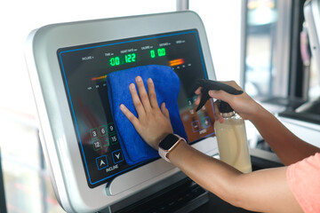 partial view of woman cleaning sports equipment in gym on blurred foreground	