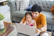 © Kris Tan - Father and daughter learning and playing with Notebook computer at home