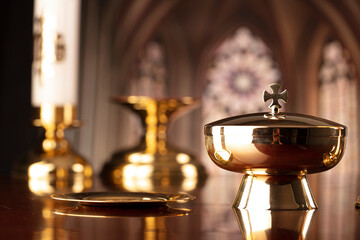 First Holy Communion. Catholic religion theme. Crucifix, the Cross and Golden chalice and wafer on the altar in the church.