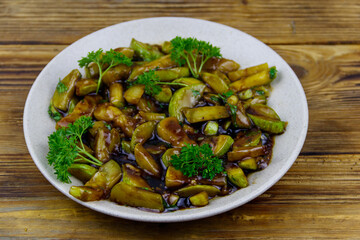 Tasty marrows in soy sauce on wooden table