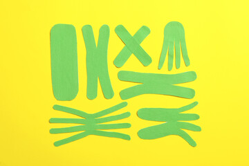 Wall Mural - Different kinesio tape pieces on yellow background, flat lay