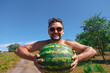 © aaalll3110 - a man on the beach and holds a watermelon. ripening of summer berries Joyful emotions and mood. Summer picnic.