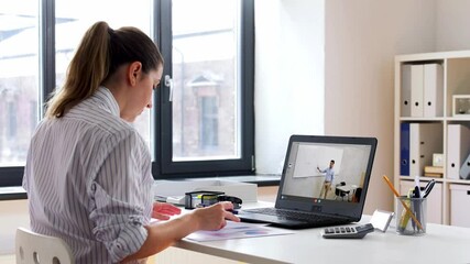 Wall Mural - remote job, technology and people concept - young businesswoman with laptop computer and papers working at home office and having video conference