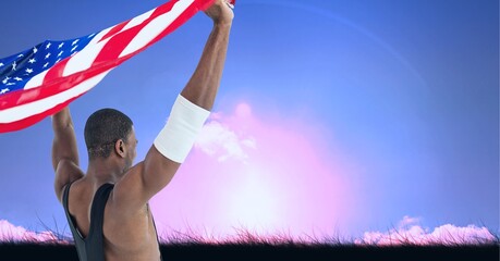 Wall Mural - Composition of male athlete holding american flag against sky