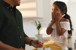 © Wavebreak Media - Happy hispanic daughter sitting on counter making face to father preparing vegetables in kitchen