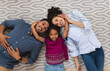© Wavebreak Media - Portrait of smiling hispanic mother, father and daughter lying floor embracing