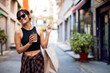 © JustLife - Portrait of smiling woman holding shopping bags. Beautiful woman enjoying in shopping...