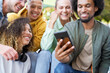 © gpointstudio - Close up of group of happy people sitting with phone