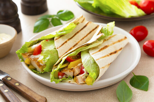 wrap burrito sandwich or kebab with flatbread with vegetables and white meat.