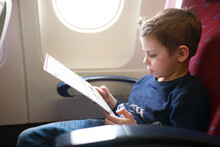 Child Studying Safety Instructions On Airplane