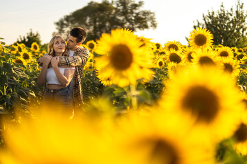 Wall Mural - Pareja de jovenes en un campo de girasoles