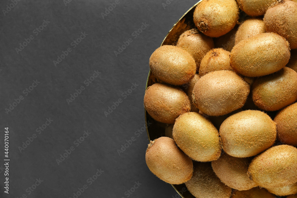 Plate with ripe kiwi on dark background