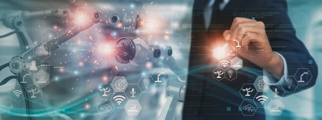 Wall Mural - industry engineer manager in factory,using visual screen interface ,control automated robot arm mach