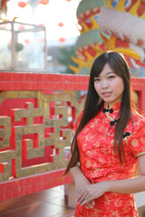 Wall Mural - beauty woman wear red cheongsam looking and smile in chinese new year