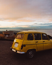 Vertical Shot Of An Old-style Yellow Car With A Seascape In The Background