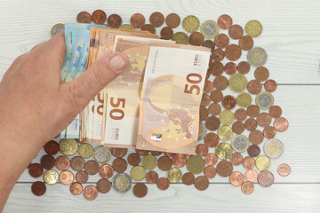 Canvas Print - Overhead shot of euro currency coins and banknotes and male hand counting money