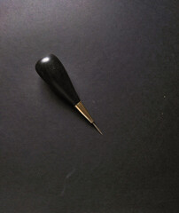 Sticker - Vertical top view of an awl handle on a black surface