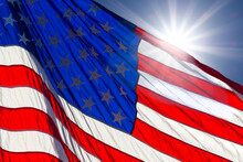 Sunburst Behind America Flag In Blue Sky