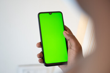 Closeup shot of hand using mobile phone with Green screen, Finger swiping up and down in green screen of the mobile. Green screen mockup template of Mobile phone, Chroma key	