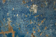 Cracked blue paint on a concrete wall. Natural background with cracks from the time of exposure.