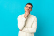 © luismolinero - Young caucasian handsome man isolated on blue background thinking an idea while looking up