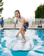 © LIGHTSY STUDIO/Westend61 - Boy surfing on surfboard in swimming pool