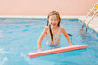 © LIGHTSY STUDIO/Westend61 - Smiling girl with swimming float in pool