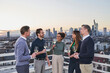 © Annika List/Westend61 - Entrepreneurs with drinks talking in city during sunset