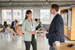 © Annika List/Westend61 - Businesswoman discussing with colleague at education even in office