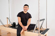 © Antonio Ovejero Diaz/Westend61 - Smiling man sitting on pilates machine in exercise room