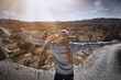 © Arman Zhenikeyev/Westend61 - Male tourist with arms outstretched standing on rock in Cappadocia during sunny day, Turkey