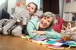 © Stefanie Aumiller/Westend61 - Girl leaning with toy on woman lying down in nursery