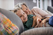 © Stefanie Aumiller/Westend61 - Happy grandmother and granddaughter resting on sofa in living room