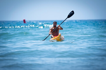 Man kayaking on the beach during summer vacation