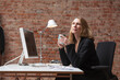 © Studio 27/Westend61 - Contemplating businesswoman having tea while sitting at desk in office