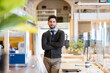 © Emma Innocenti/Westend61 - Smiling male professional with arms crossed standing in coworking office